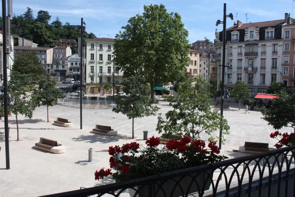 Blick auf einen Stadtplatz mit Bänken und Bäumen in der Unterkunft Hôtel du Midi in Annonay