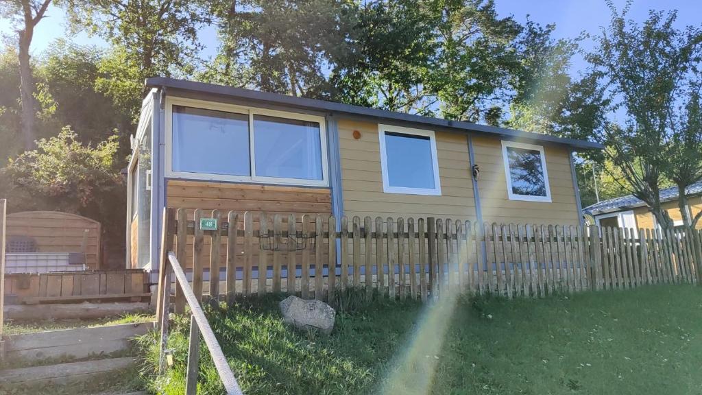 una casa pequeña con una valla en un patio en Bungalow/chalet (HLL) à Serre Ponçon, proche stations de ski, en Pontis