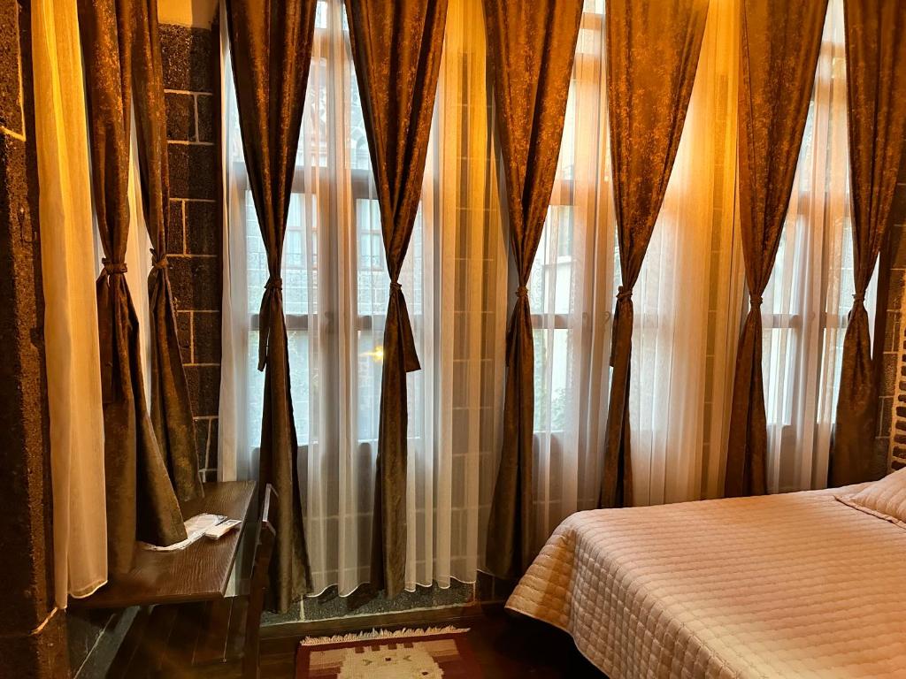 a bedroom with a bed and a window with curtains at Karga Butik Otel in Diyarbakır