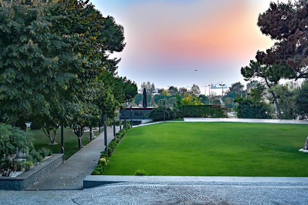 a park with a green lawn and trees at Denizatı Plus Hotel in Istanbul