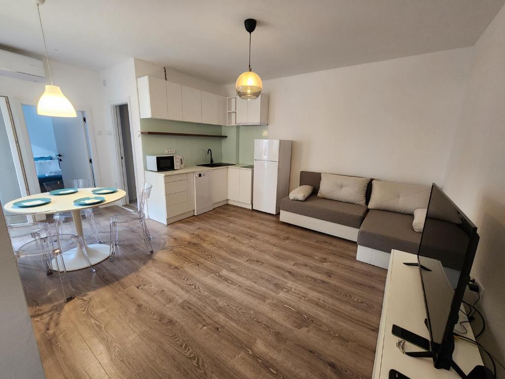 a kitchen and a living room with a table and a couch at Modern Cozy Suite - Vracar in Vračar (historical)