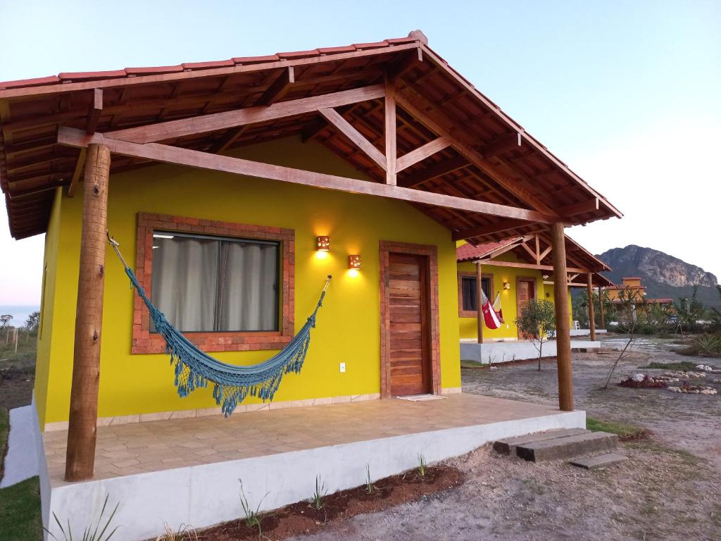 a small yellow house with a wooden roof at Recanto Cachoeiras de Ibicoara in Ibicoara