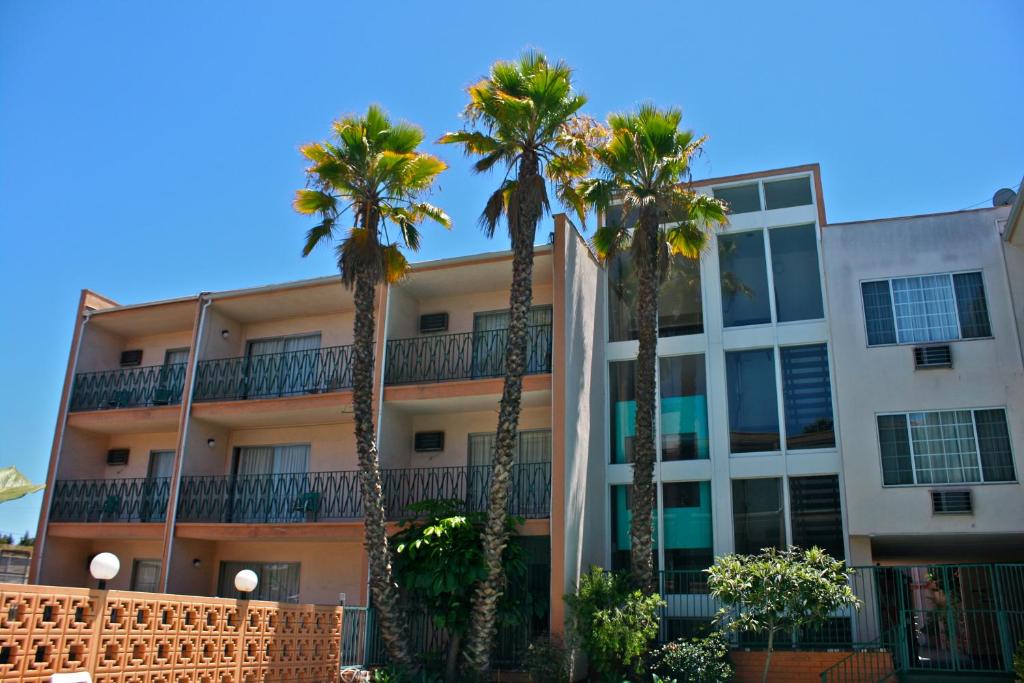 un edificio con palmeras delante en Royal Century Hotel at LAX, en Inglewood