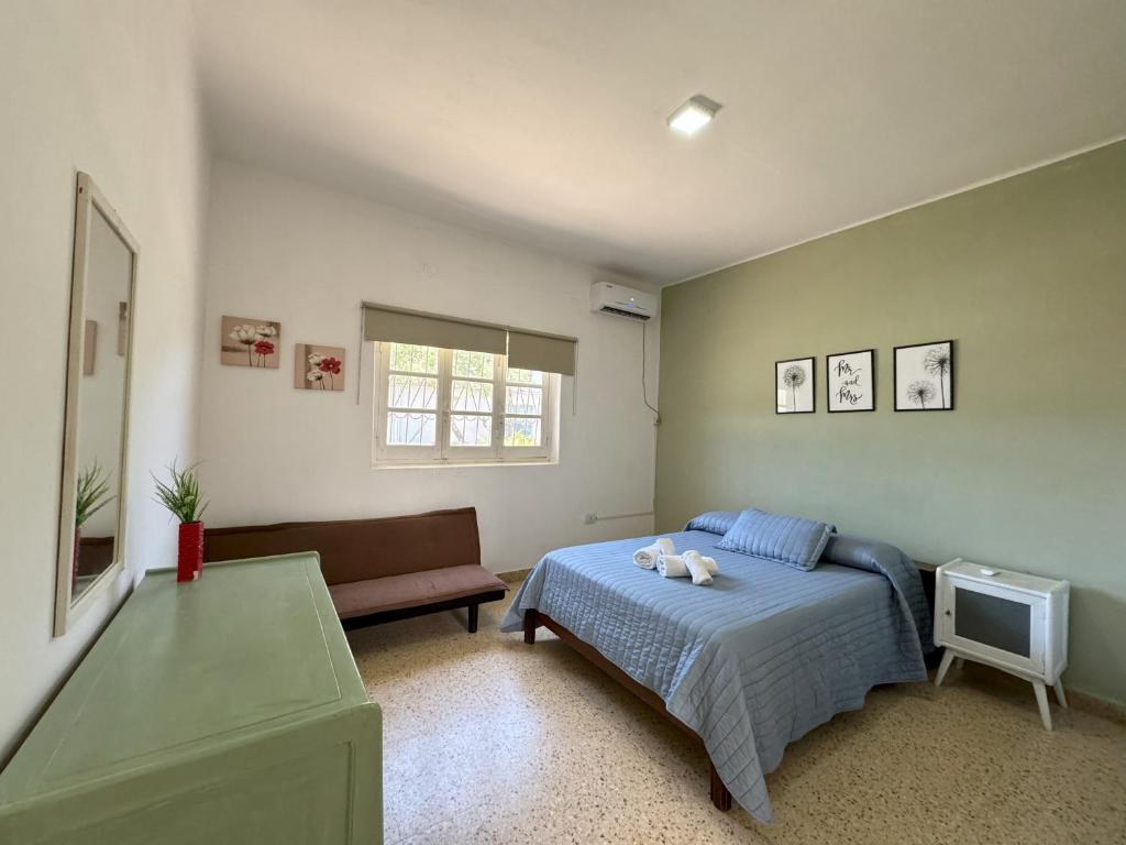 a bedroom with a bed and a chair and a window at La Pilar in Formosa