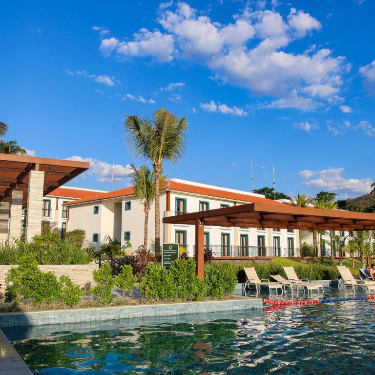 a resort with a swimming pool and a building at Flat da Mata - Resort Quinta Santa Bárbara in Pirenópolis