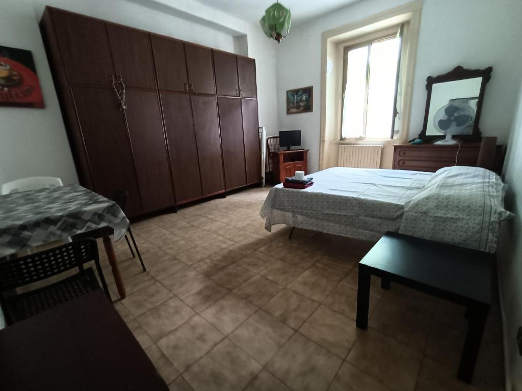 1 dormitorio con cama, mesa y ventana en Casa mare a 200 m, en Cosenza