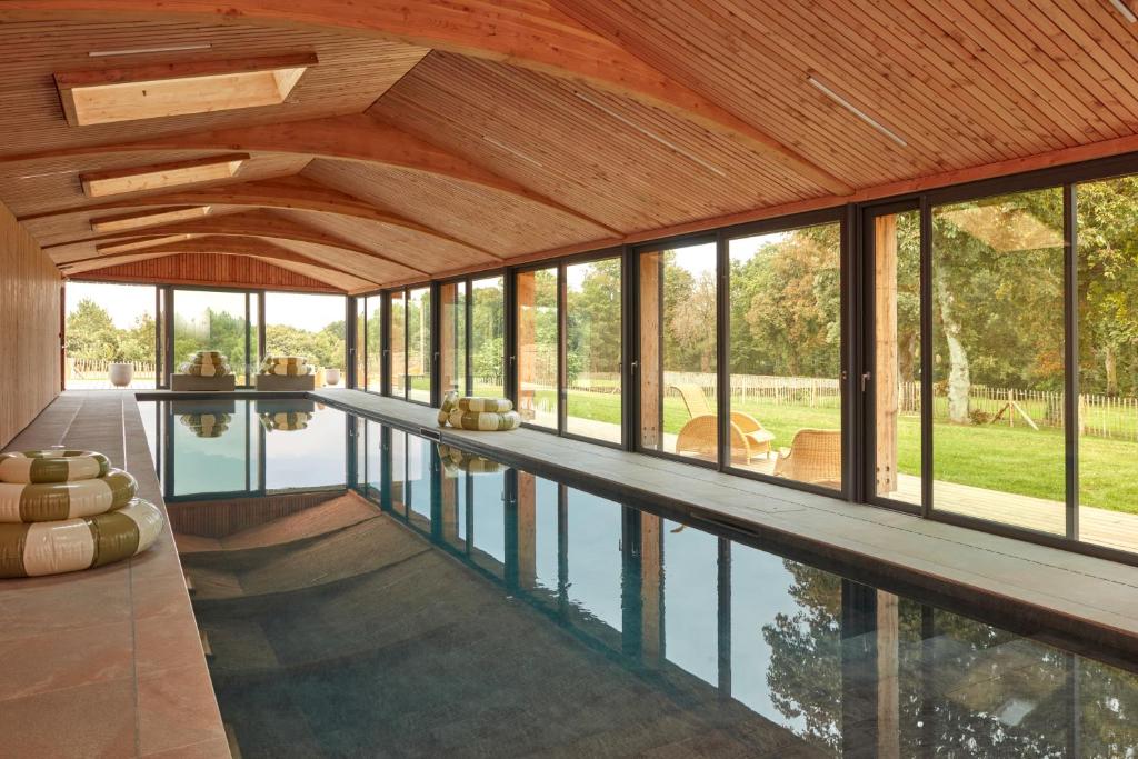 an indoor pool in a house with glass windows at DOMAINE LE MEZO in Ploeren