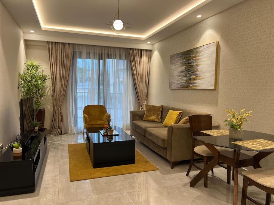 uma sala de estar com um sofá e uma mesa em Mirage Residence Apartment Accra em Acra