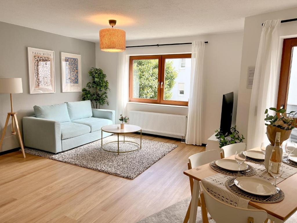 een woonkamer met een bank en een tafel bij Boho Home - mit Balkon, Parkplatz und Netflix in Trier