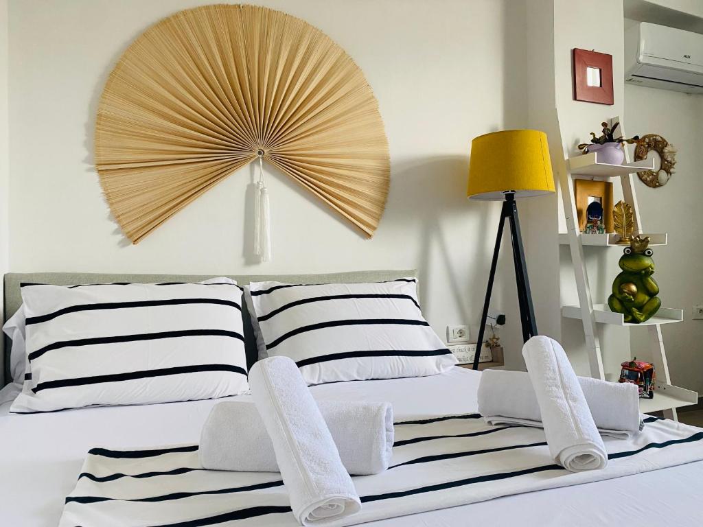 a bedroom with a bed with a large fan on the wall at Lola’s Apartment in Durrës