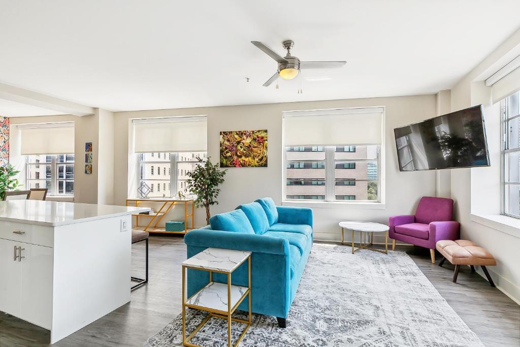 a living room with a blue couch and purple chairs at Modern Condo Walking Distance to Must-See Attractions of NOLA in New Orleans