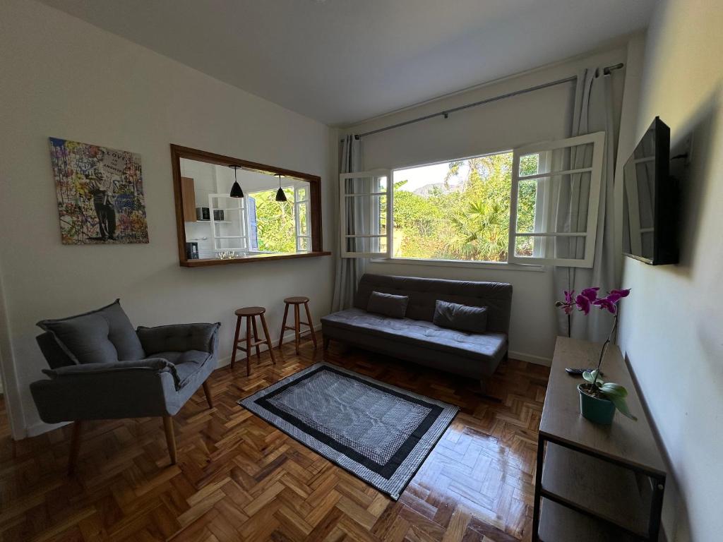 a living room with a couch and two windows at Casa Palácio de Cristal no centro Histórico de Petrópolis in Petrópolis