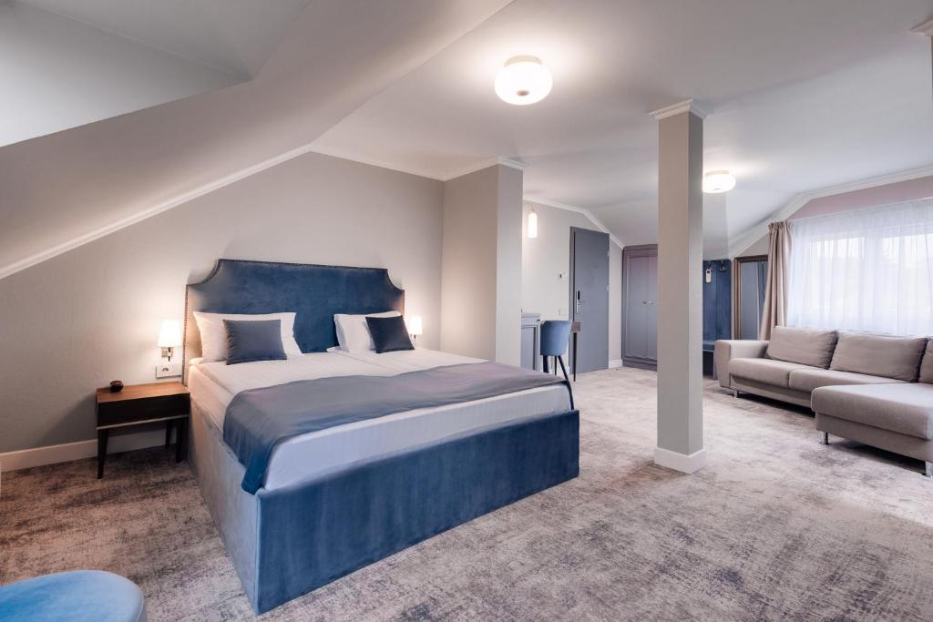 1 dormitorio con 1 cama grande y 1 sofá en Hotel Meridian, en Cluj-Napoca