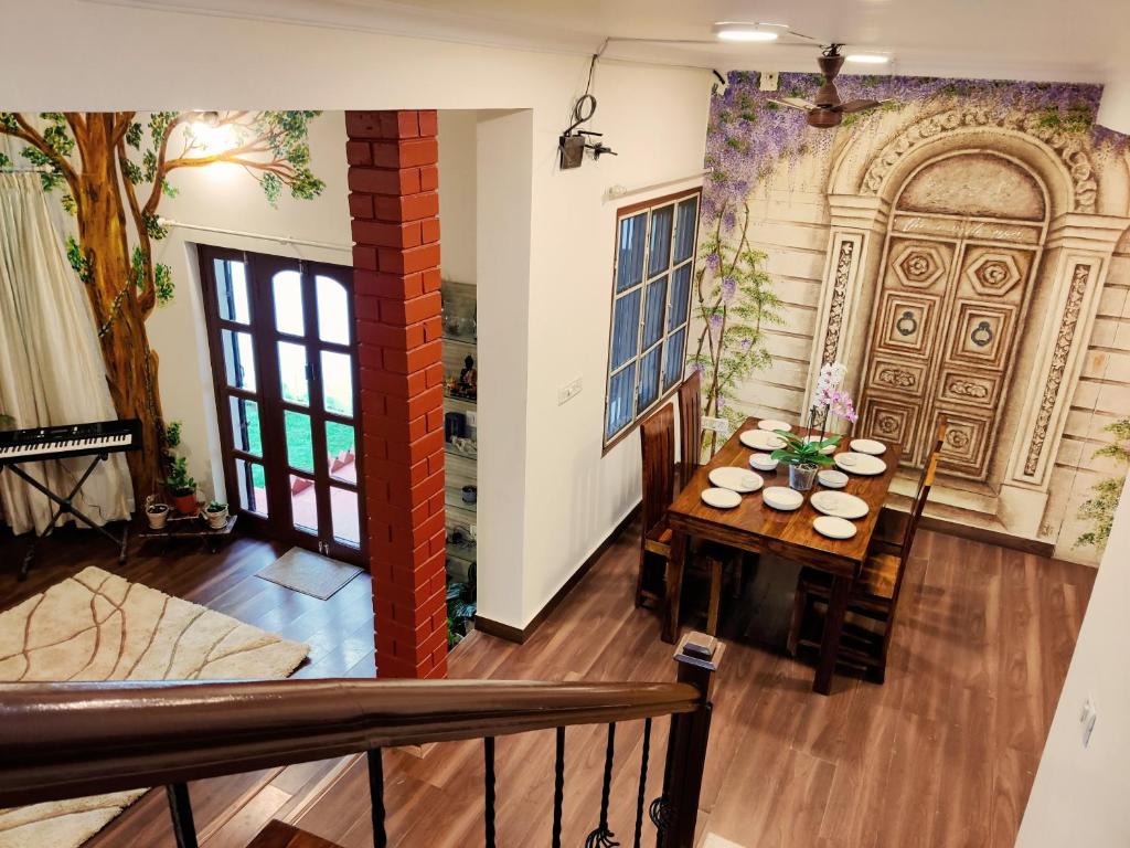 uma sala de jantar com uma mesa e uma porta em The Rustic Manor - Homestay em Bangalore