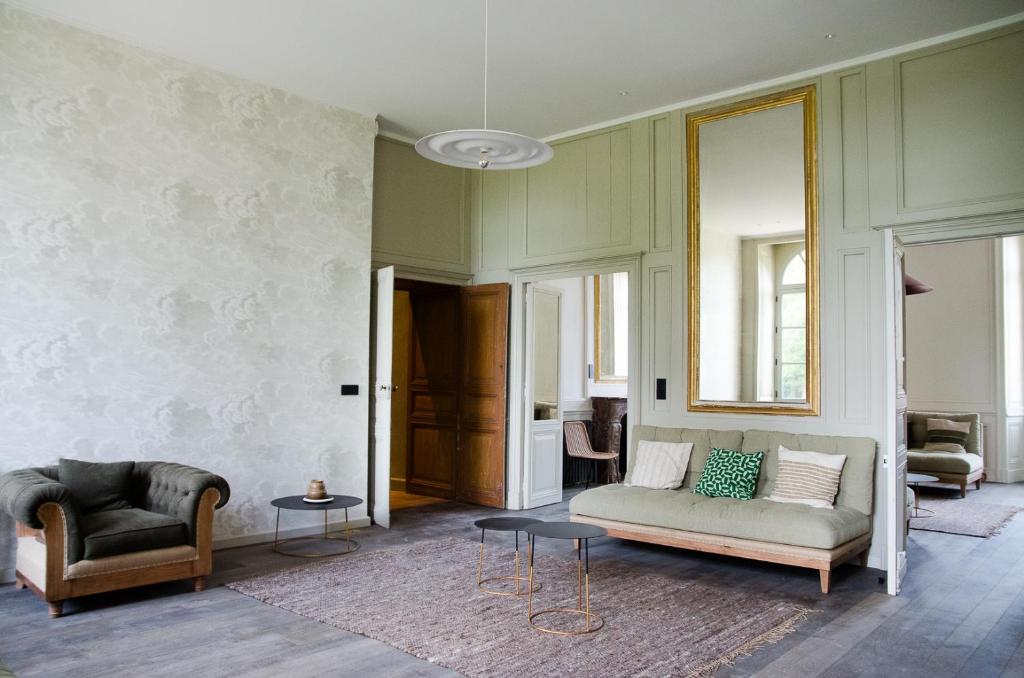 a living room with a couch and a chair at DOMAINE LE MEZO in Ploeren