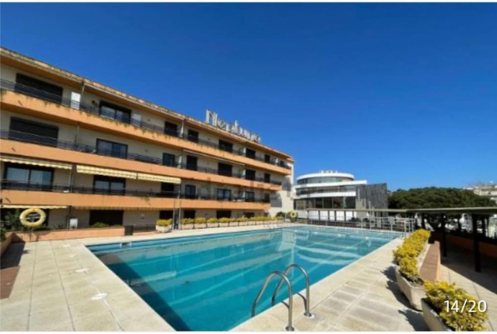 une grande piscine en face d'un bâtiment dans l'établissement Apartamento céntrico Playa de Aro con piscina., à Platja d'Aro