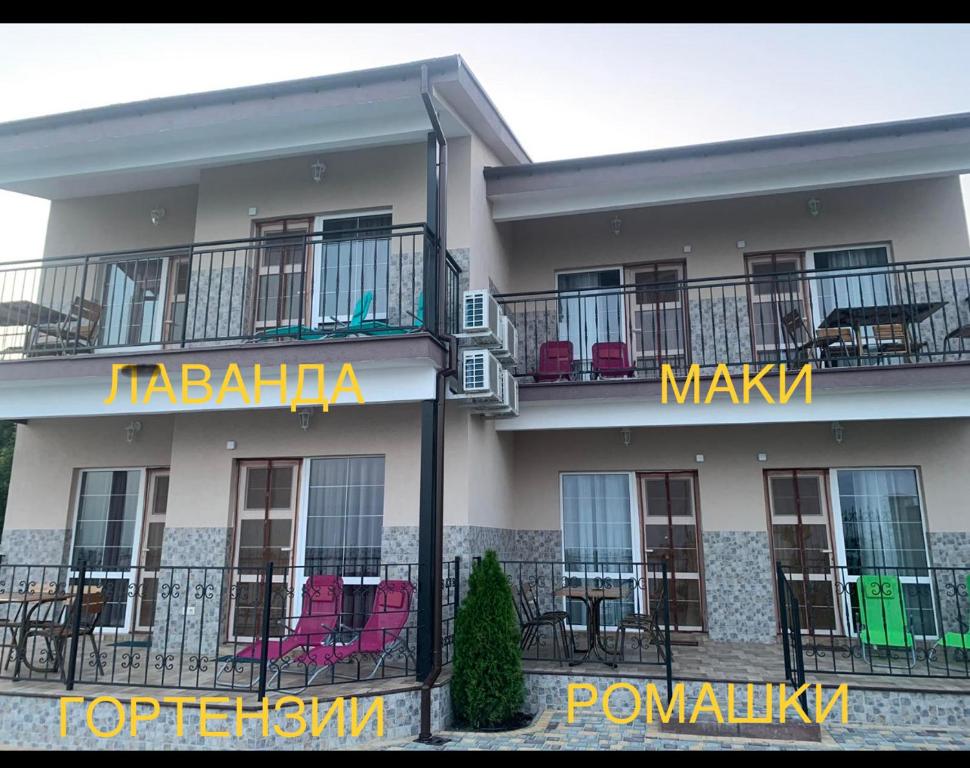a large apartment building with chairs on the balcony at Flower Breeze in Chebanka