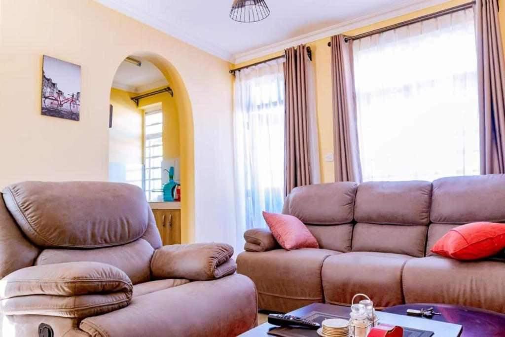 een woonkamer met een bank en een stoel bij Nyatana suite (Fully furnished apartments) in Narok