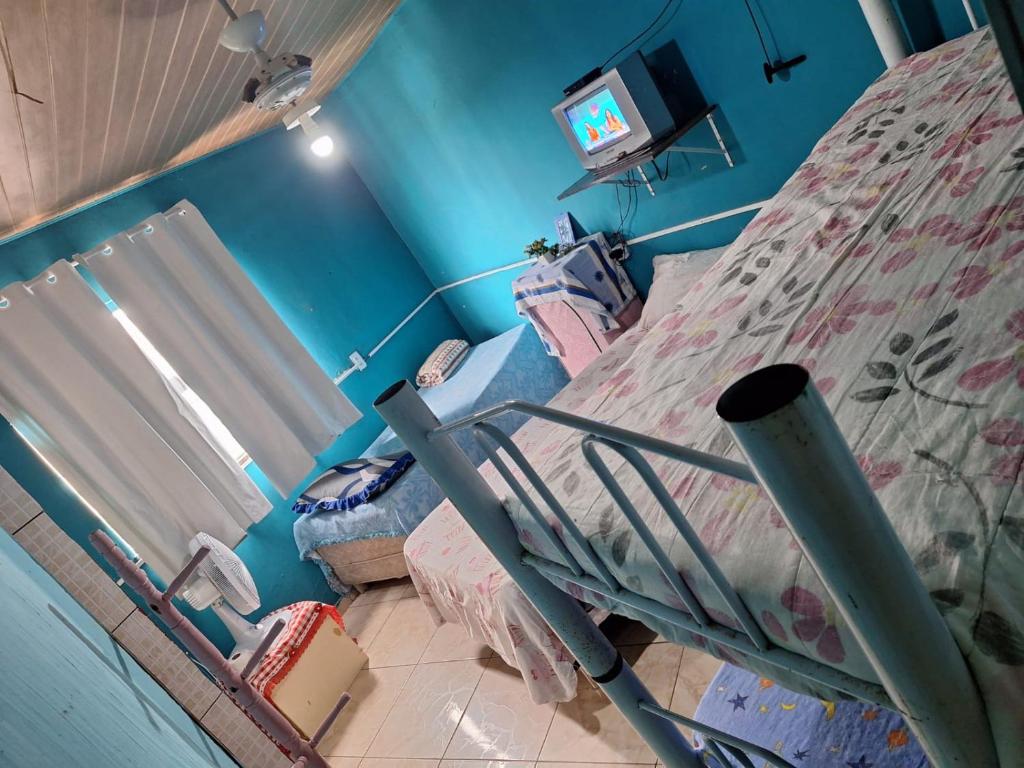 Habitación hospitalaria con cama y TV en Mel Pousada, en Macaé