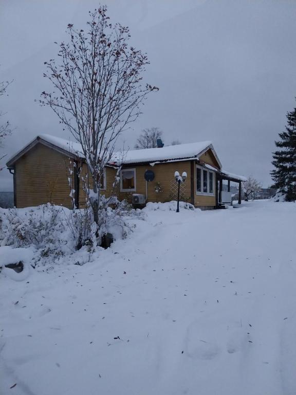 uma casa com neve no chão em frente dela em Gula huset em Rottneros