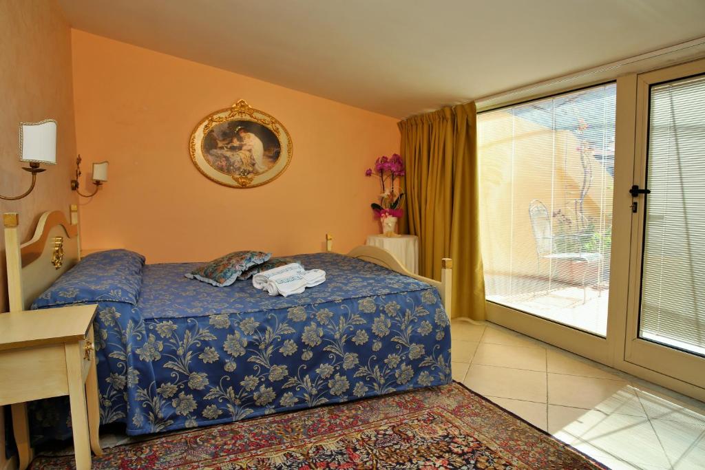 a bedroom with a blue bed and a balcony at Hotel Scilla in Scilla