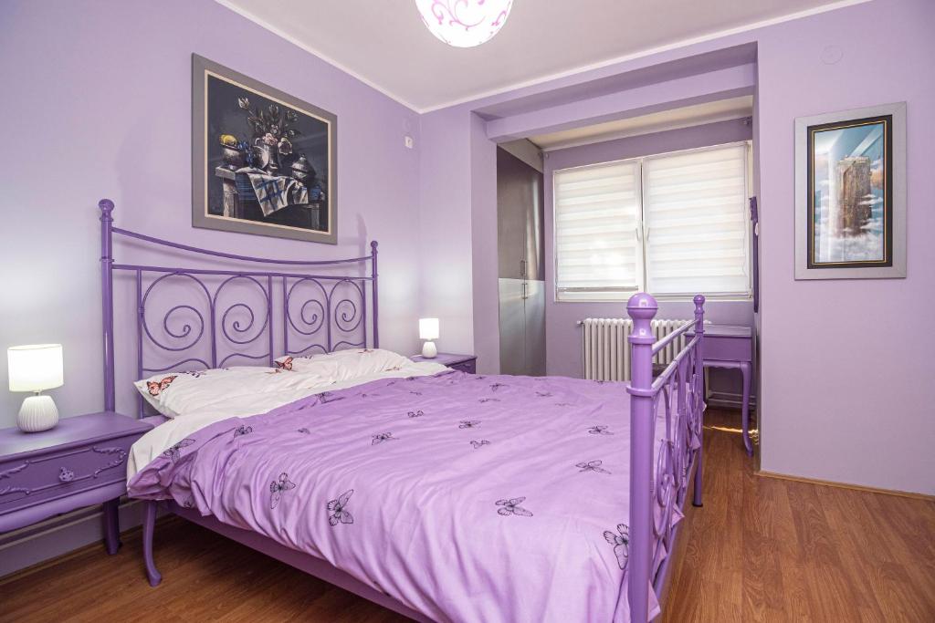 a purple bedroom with a purple bed and a window at Q9 in Kragujevac