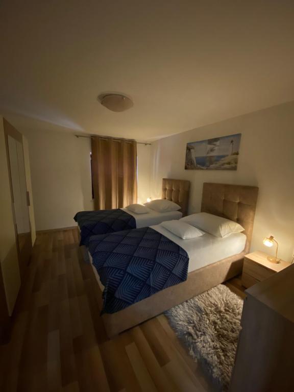 a bedroom with two beds and a rug at Apartment Bilic in Split