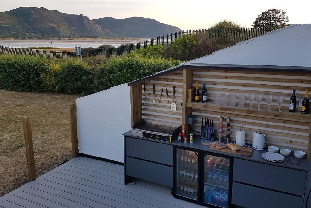 a bar on a deck with a view of the beach at Deganwy Beach house 3BR in Deganwy