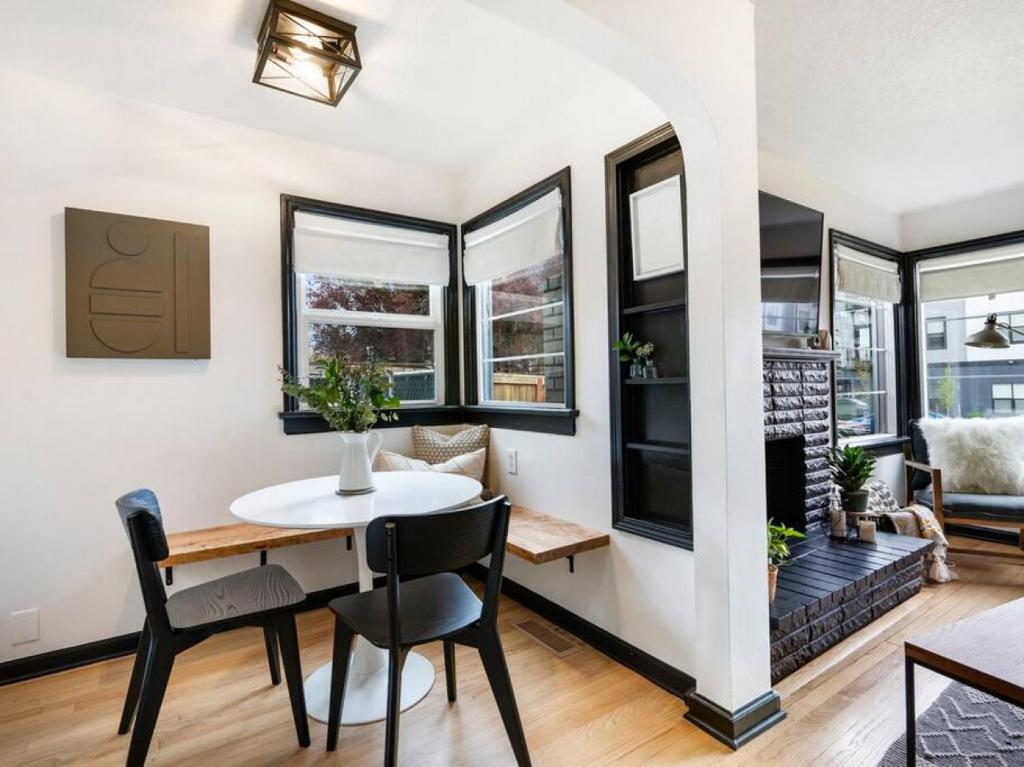 a dining room and living room with a table and chairs at Picture Perfect Bungalow in the heart of DT Vancouver in Vancouver