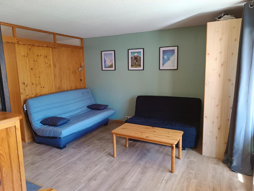 Sala de estar con sofá azul y mesa de centro en APPT 4-6 PERS 28m2 tout équipé, 30m des pistes en Saint-Jean-dʼAulps