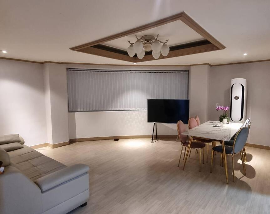 a living room with a couch and a table with chairs at Haru Airport Stay Gimpo in Seoul