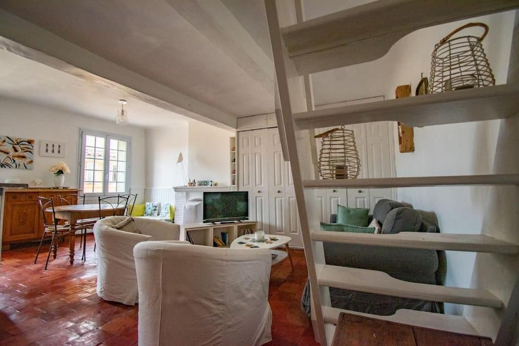 un salon avec des chaises blanches et une table dans l'établissement Charmant T3 centre historique, parking, à Aix-en-Provence