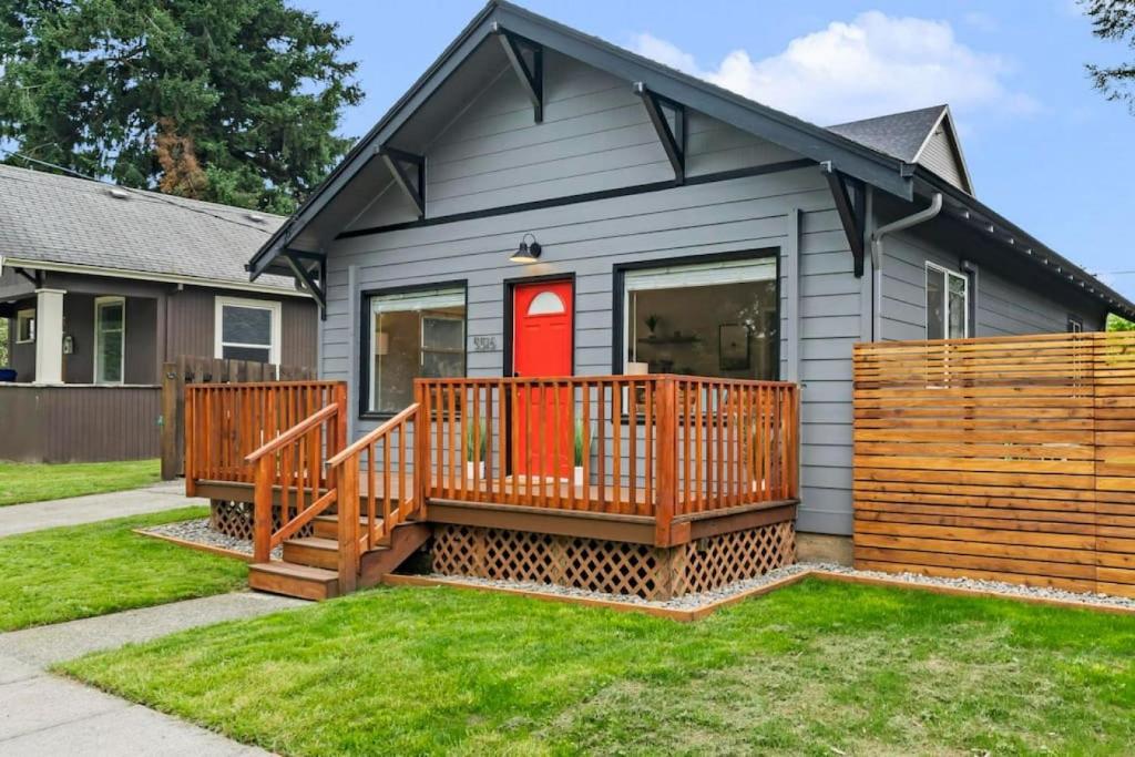 une maison avec une terrasse et une porte rouge dans l'établissement Cheerful 2-bedroom Home Near UP and St. Johns, à Portland