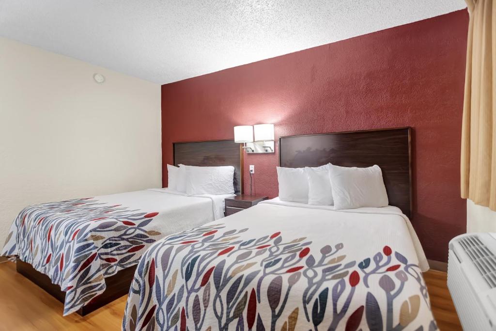 a hotel room with two beds and a red wall at Qubed San Antonio in San Antonio