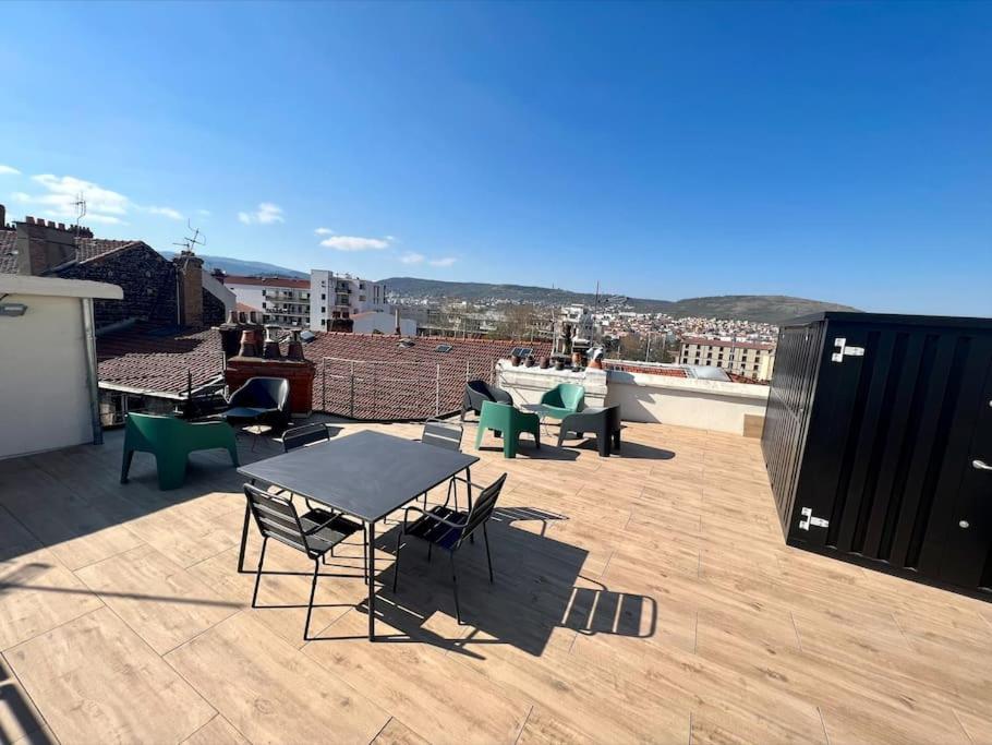 un patio con mesa y sillas en la azotea en Appartement superbe Rooftop 70m2 Clermont Ferrand, en Clermont-Ferrand