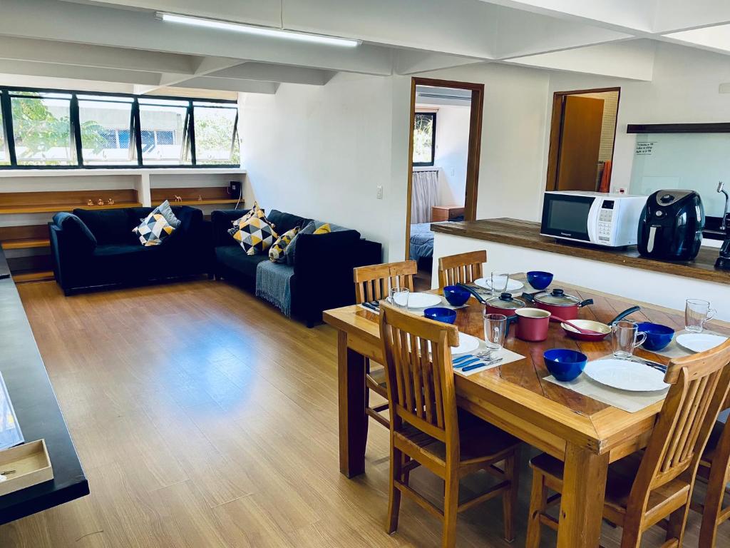 a dining room and living room with a wooden table at Apartamento amplo a 4km do aeroporto internacional de Guarulhos Cecap in Guarulhos