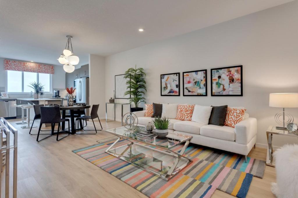 ein Wohnzimmer mit einem weißen Sofa und einem Tisch in der Unterkunft Luxurious Modern Home With King Bed & Office in Calgary