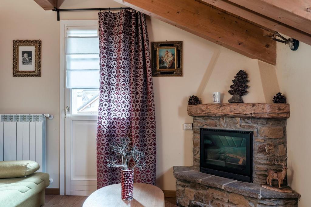 a living room with a fireplace and a television at Residence MV in Ponte di Legno
