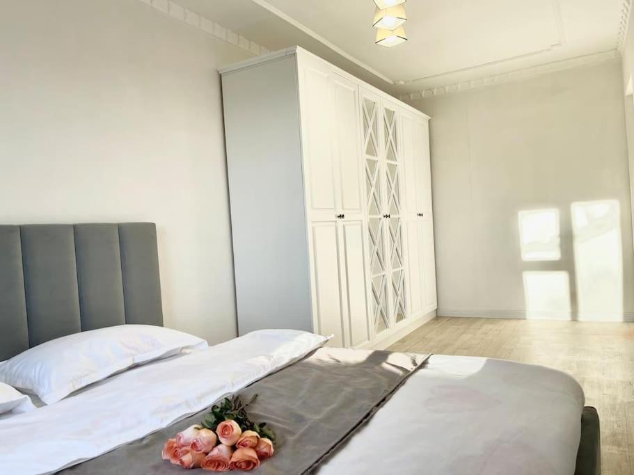 ein Schlafzimmer mit 2 Betten und einem Schrank mit Blumen darauf in der Unterkunft Квартира в самом центре in Qaraghandy