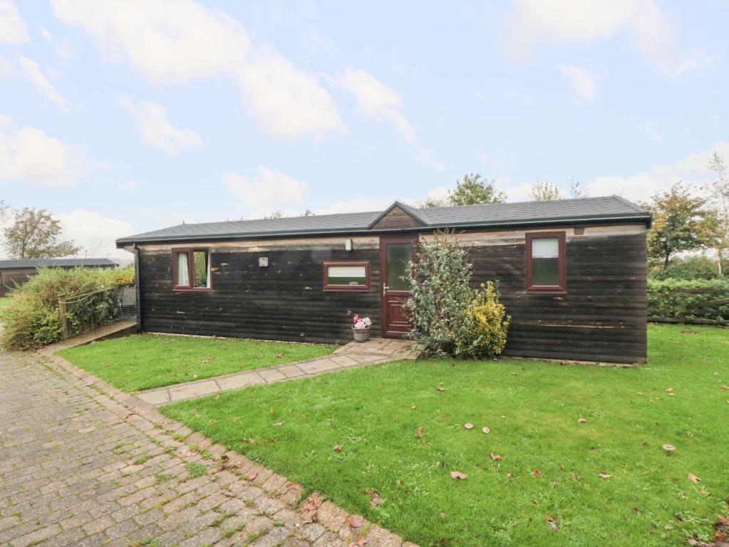 une petite maison en bois avec une pelouse dans l'établissement Hawthorne Lodge, à Skinningrove