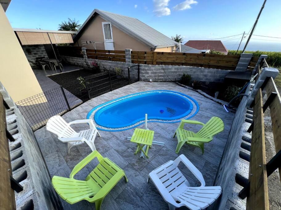 a patio with chairs and a table and a pool at L'escale du sud sauvage in Petite Île