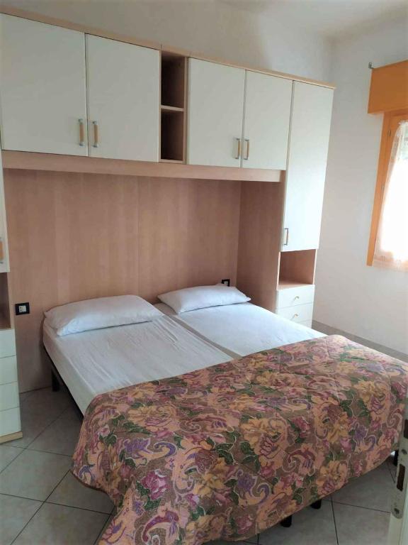 sypialnia z 2 łóżkami i białymi szafkami w obiekcie Apartments in Rosolina Mare 25092 w mieście Rosolina Mare