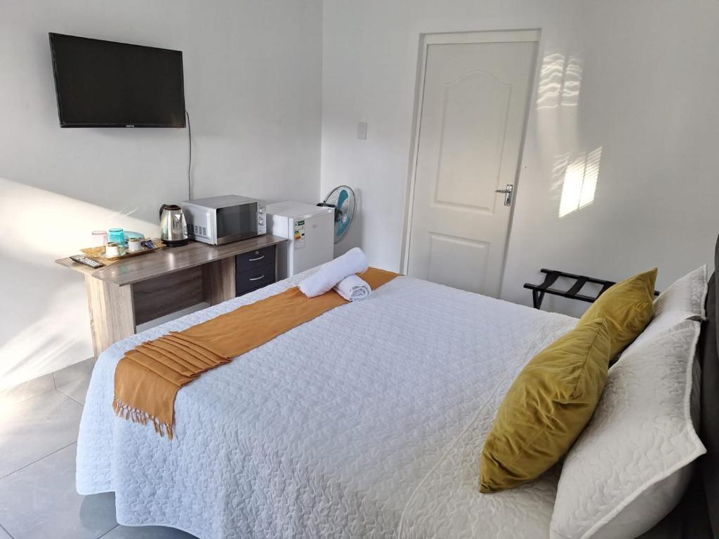 1 dormitorio con 1 cama grande y TV. en AveBulela Penthouse en Richards Bay