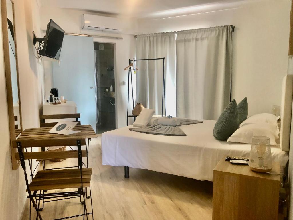 1 dormitorio con cama, escritorio y ventana en Calmaria Guesthouse en Porto Covo