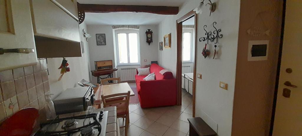 een woonkamer met een rode bank en een keuken bij Marco e Gio - 011024-LT-0192 in Riomaggiore