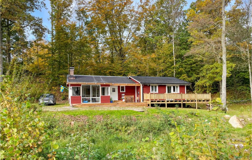 une maison rouge au milieu d'une forêt dans l'établissement Pet Friendly Home In Hstveda With Wifi, à Hästveda