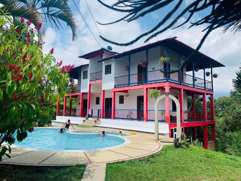 une maison avec une piscine en face de celle-ci dans l'établissement Finca Hotel Calle Jardin, à La Tebaida