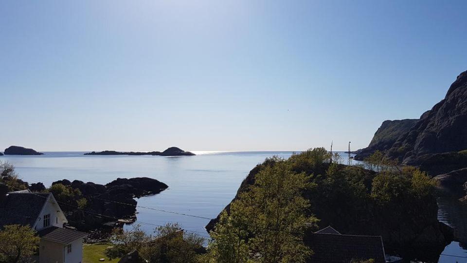 une grande étendue d'eau avec une maison sur une falaise dans l'établissement Jøssingfjord Apartments, à Sokndal