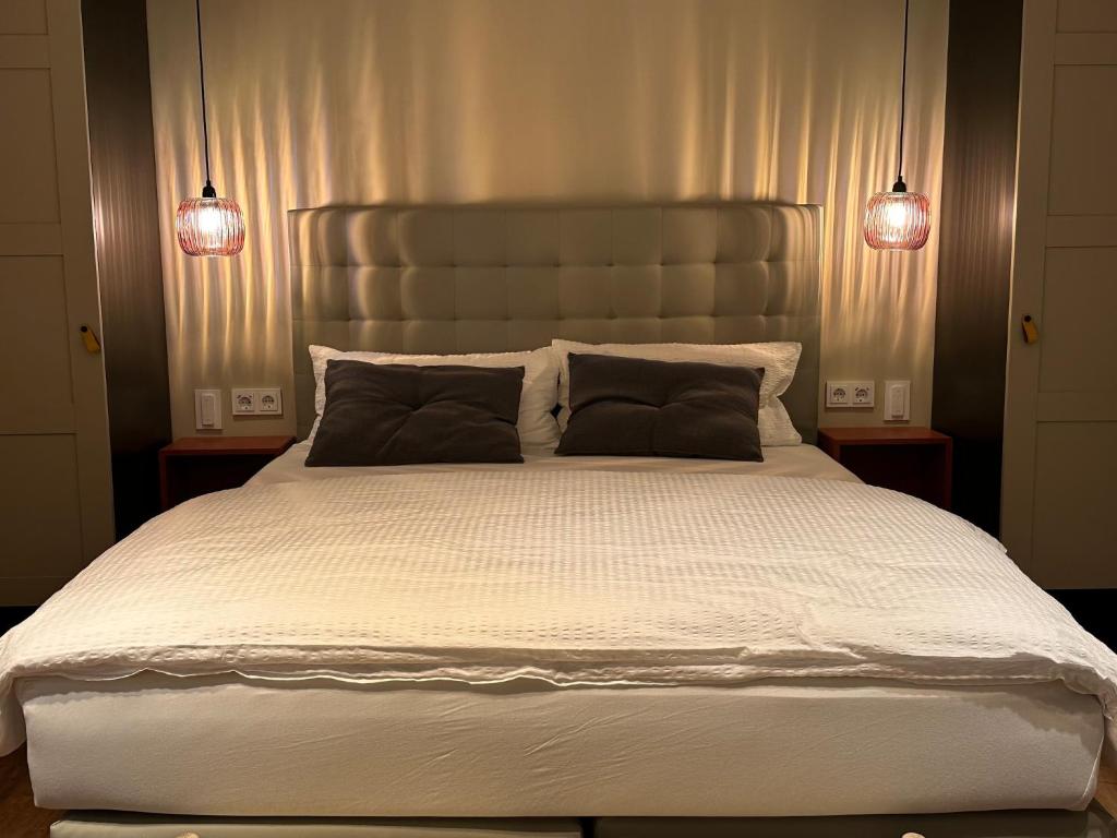 ein Schlafzimmer mit einem großen weißen Bett mit zwei Leuchten in der Unterkunft Fidschis Apartment Nr 3 in Nürtingen