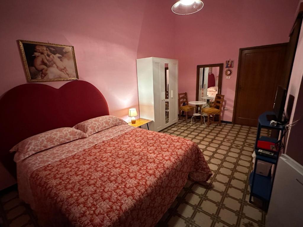 - une chambre avec un lit dans une chambre rose dans l'établissement Corte De Ritis, à Giovinazzo